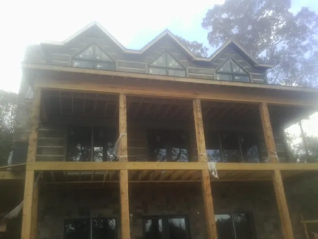 Dormers and porch framing on a large log home under construction — Roof Coating work by our crew in Fairborn