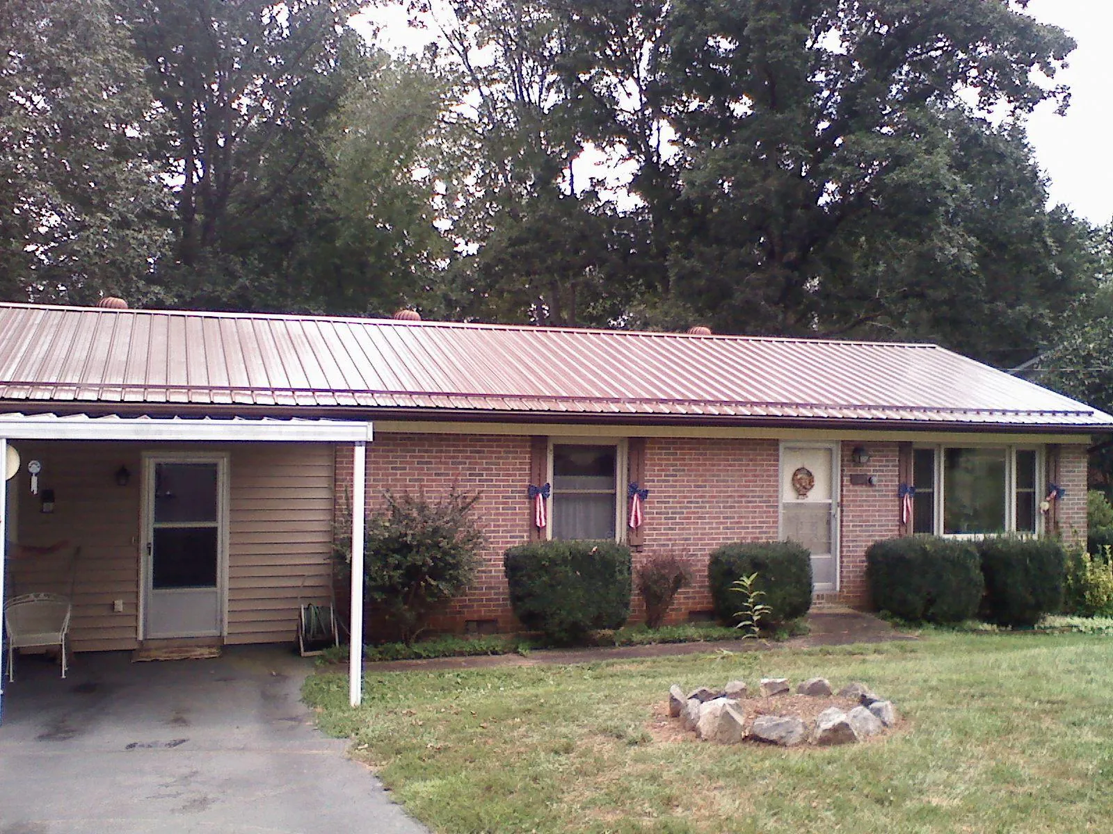 Bronze metal roof and carport on a brick ranch home — Roof Repair work by our crew in Fairborn
